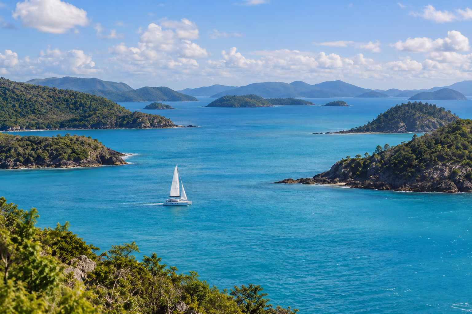 Velero entre varias islas de las Whitsundays, en una recreación fotográfica.