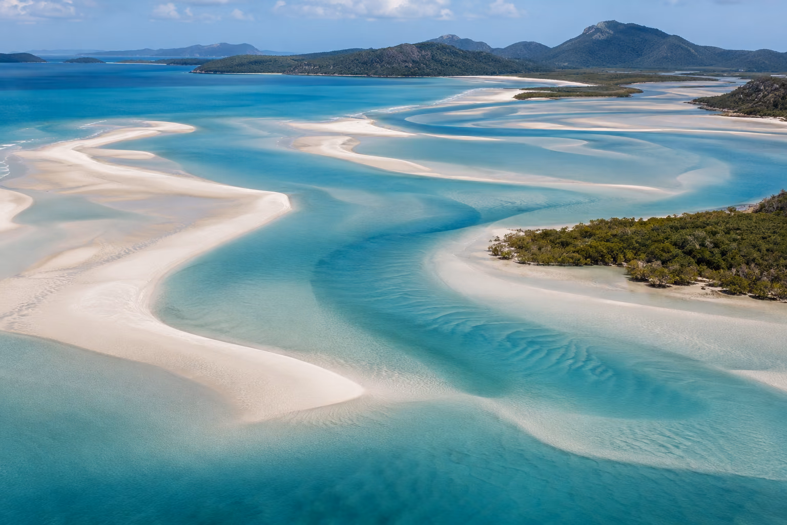 Canales de marea entre bancos de arena clara y agua turquesa en Hill Inlet; recreación editorial, no fotografía documental