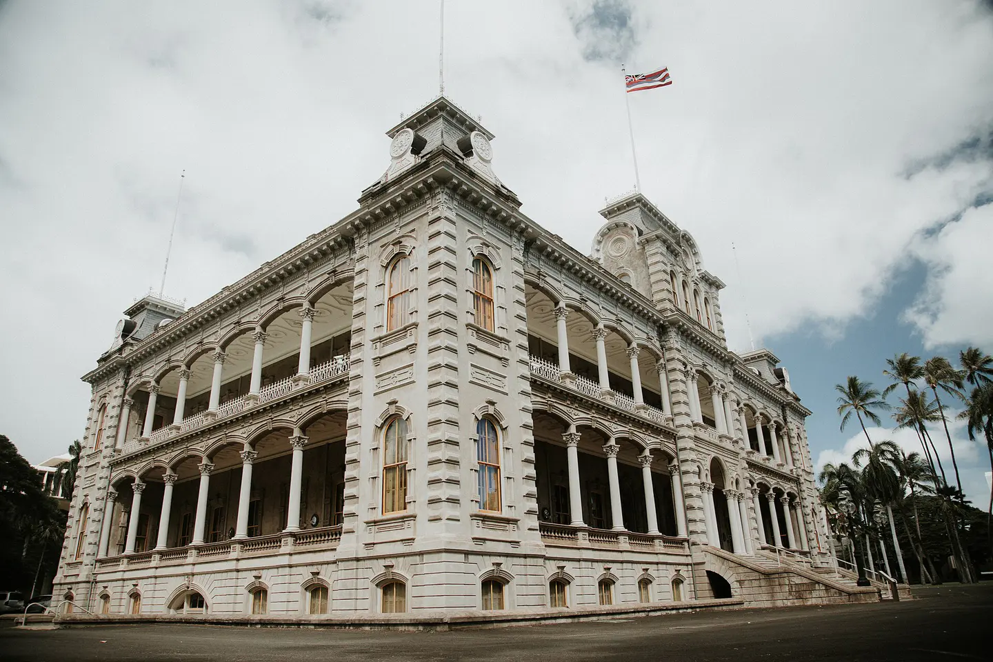 Vista en esquina del Palacio ʻIolani y la bandera hawaiana